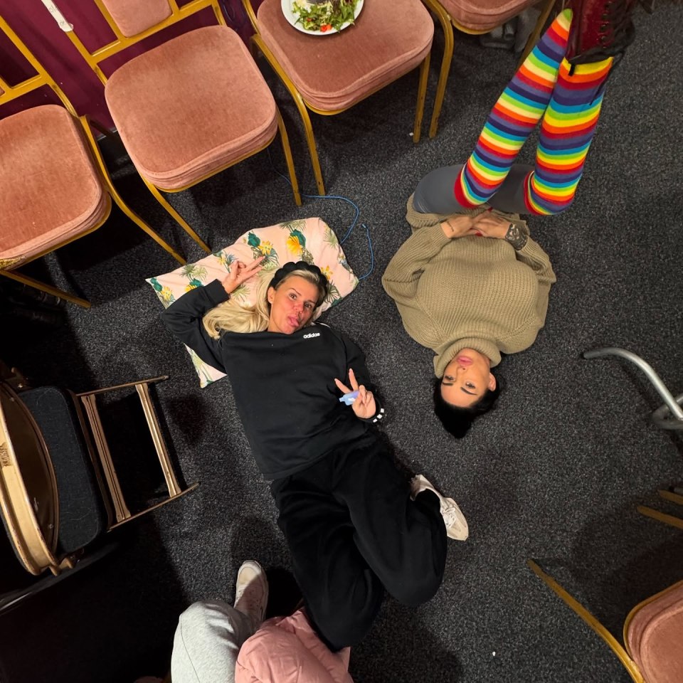 Two women lying on the floor, one wearing rainbow striped socks.