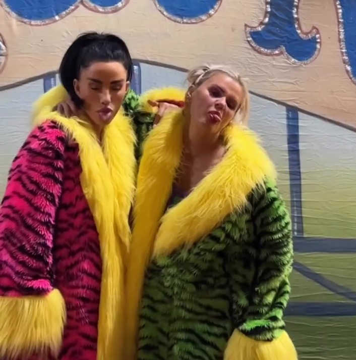 Two women in brightly colored coats make funny faces.